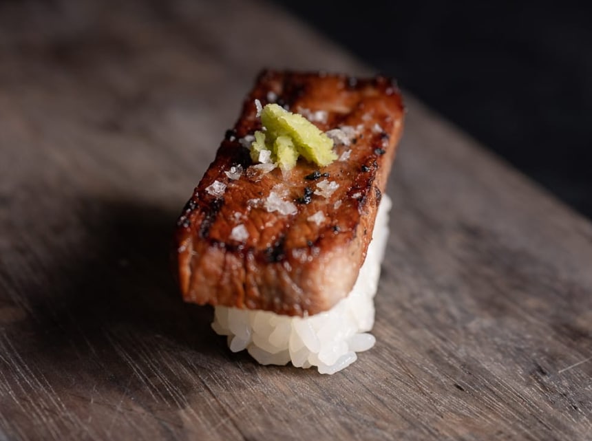 Gyutoro Nigiri served on a wooden plate.